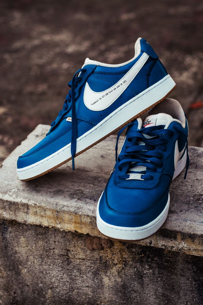 why-choose-us Close-up of trendy blue sports shoes on a concrete block outdoors.